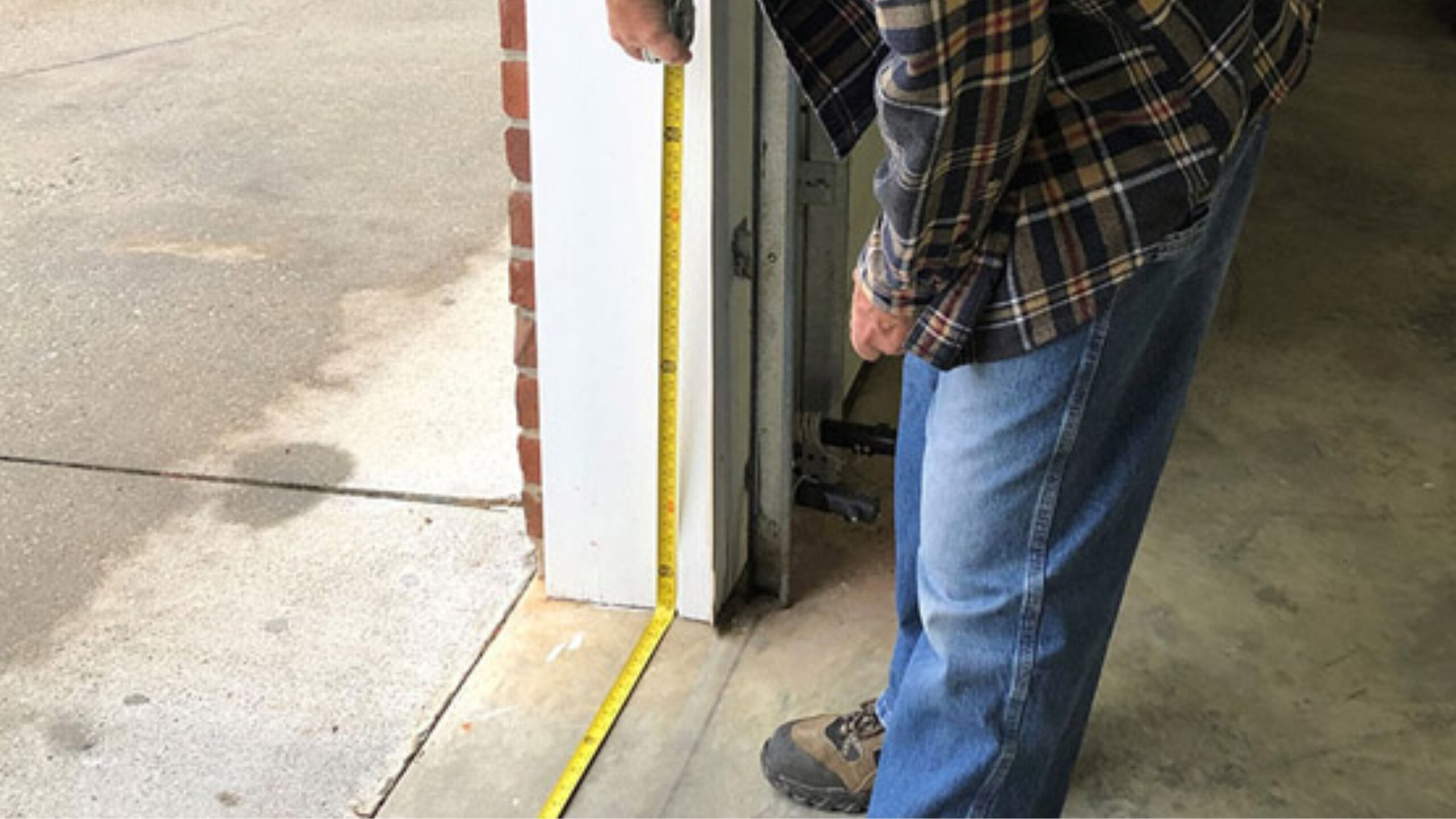 A man measuring a garage