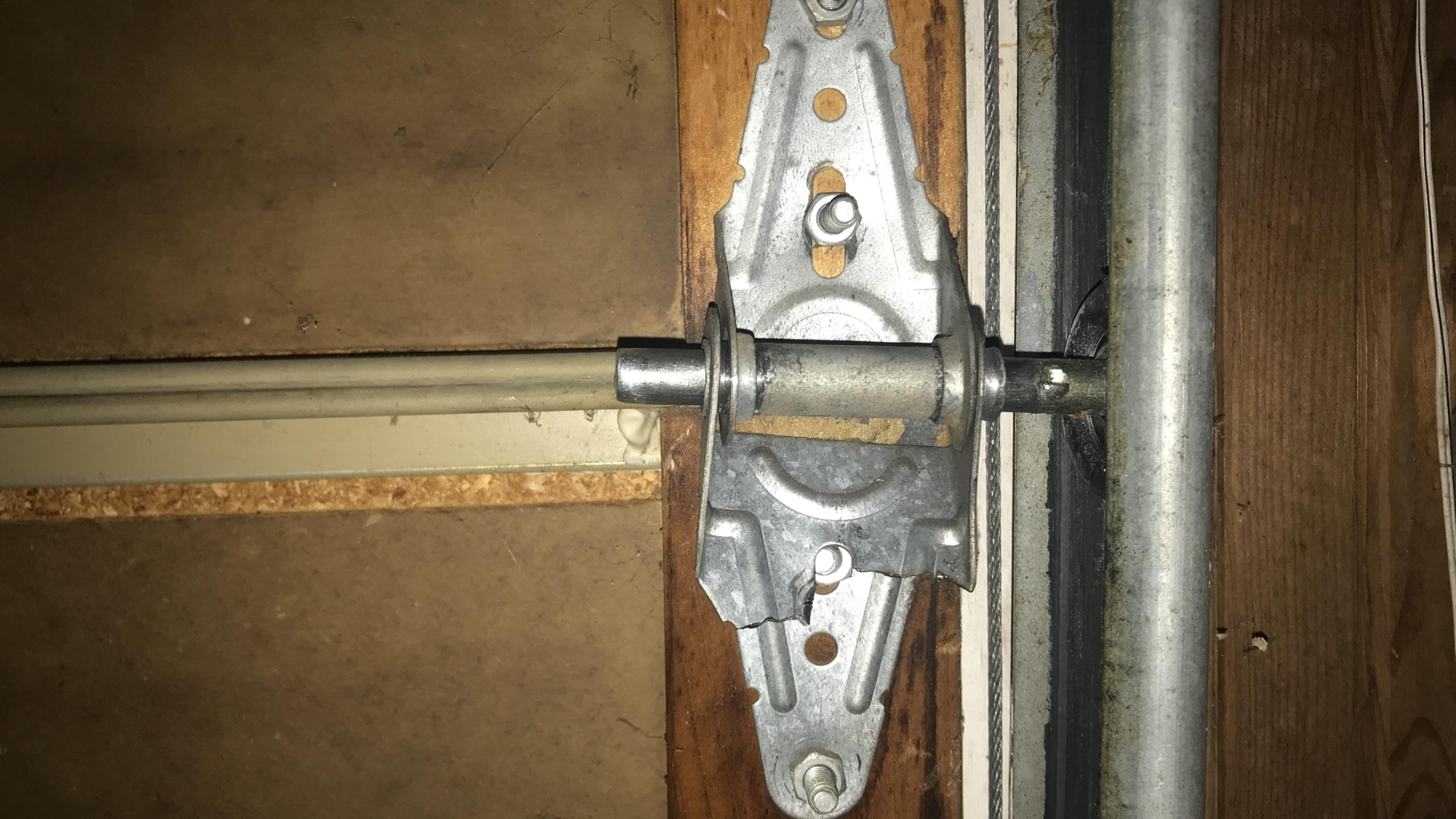 A damaged garage door hinge and roller needing replacement