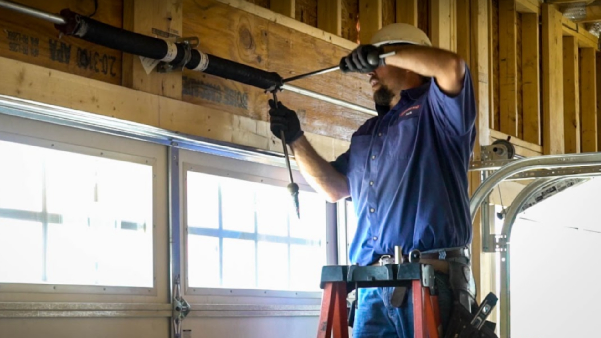 A technician replacing a garage door spring to fix a slow-moving door.