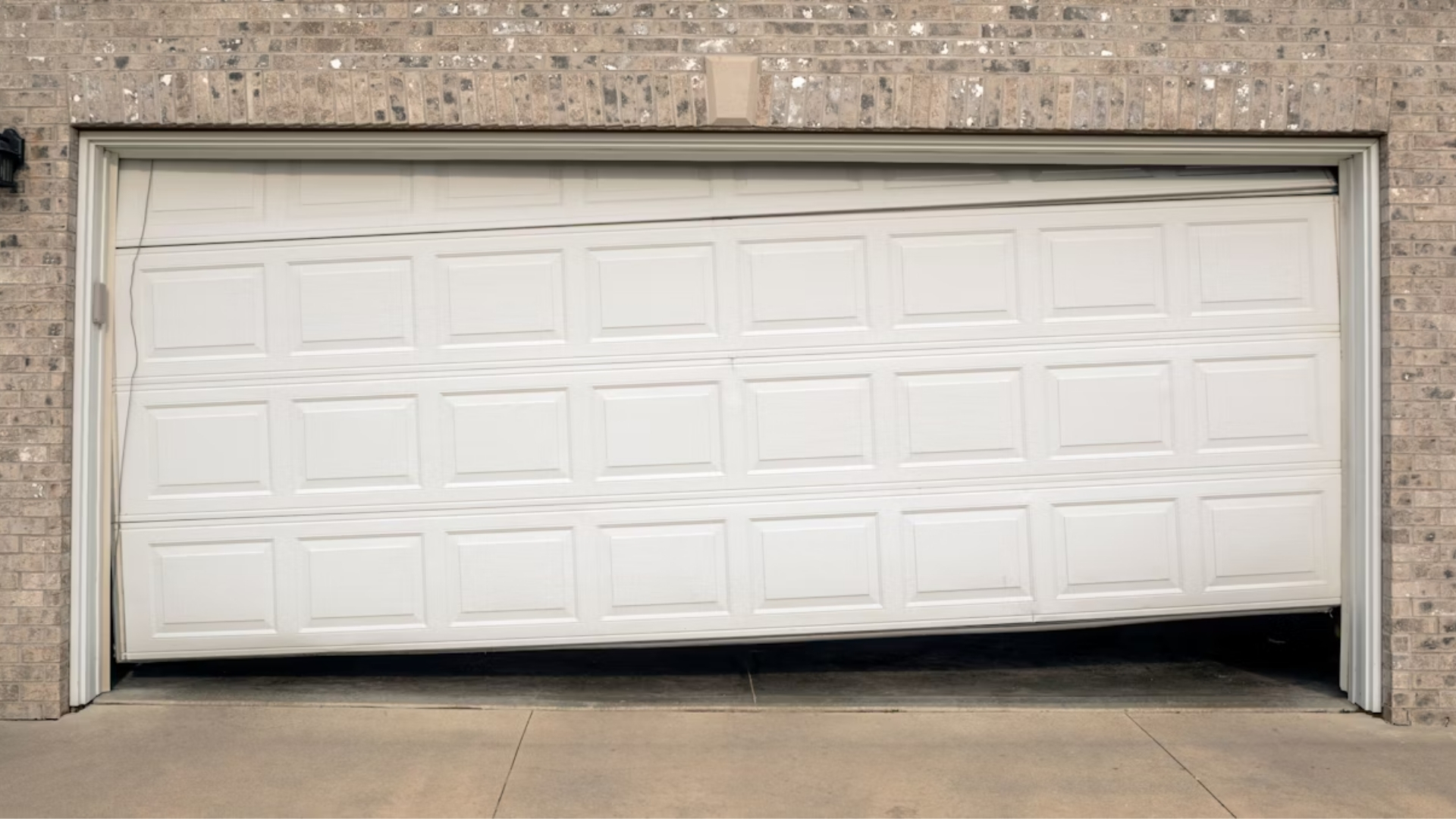 A garage door that is visibly off-track or unevenly aligned