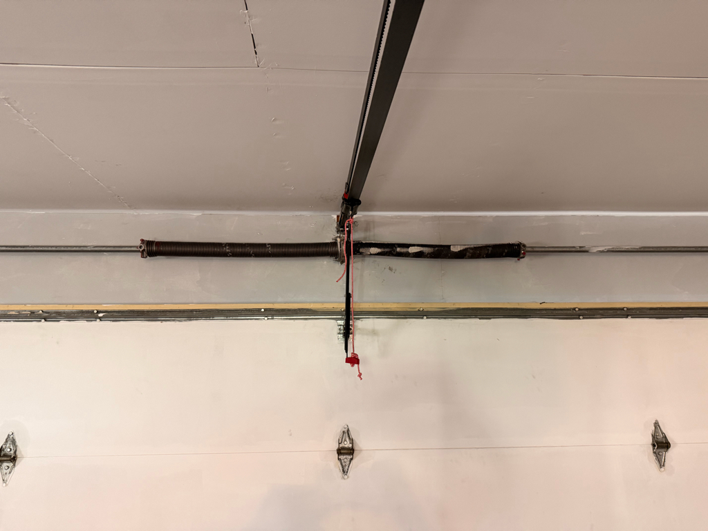  Residential garage door with a torsion spring installed.