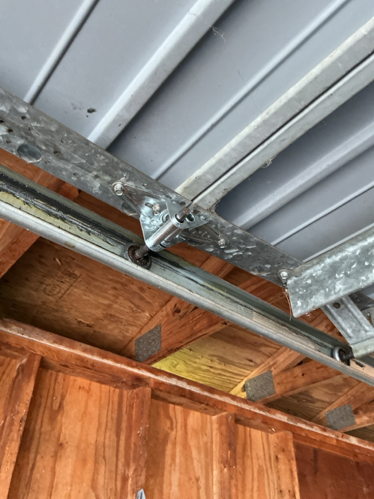   Garage door roller repair showing worn rollers on the horizontal overhead track