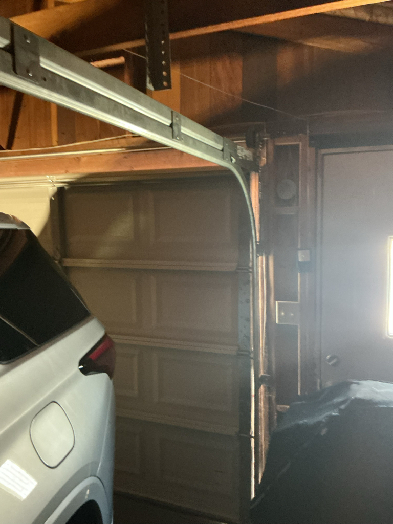 Garage door roller repair showing the curved overhead track and roller system