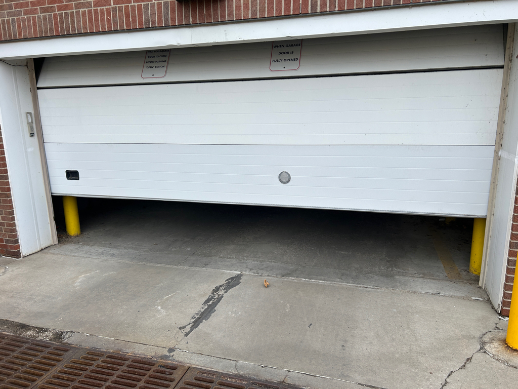 Stuck garage door partially open inside a residential garage
